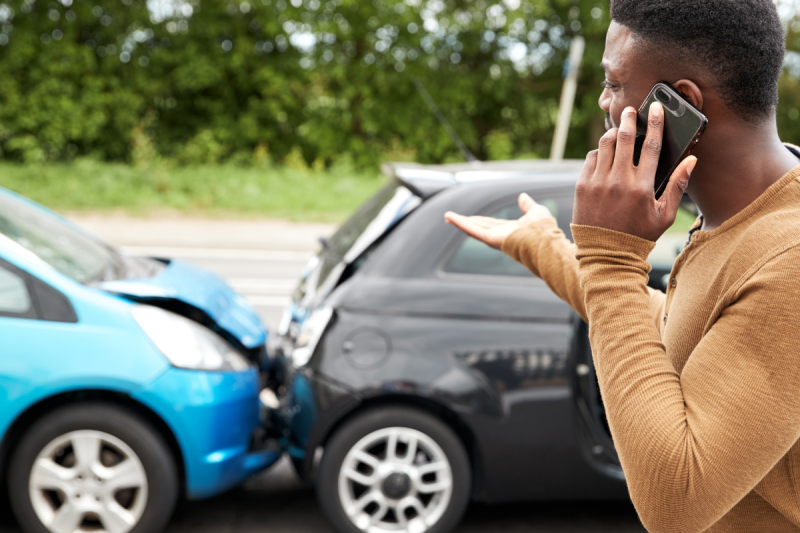 Man standing outside his car after a car accident